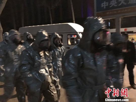 十几名身着防护服的人员头戴面具进入事发地。　胡健 摄
